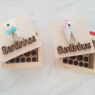 Caixas de madeira com tampas decoradas com dentes em cerâmica com laços e a palavra Dentinhos