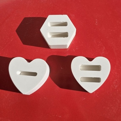 Três moldes de silicone em formatos hexagonal e coração sobre fundo vermelho