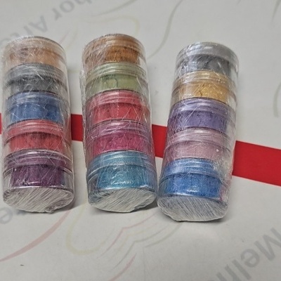 Três pilhas de pequenos recipientes circulares coloridos embalados em plástico transparente