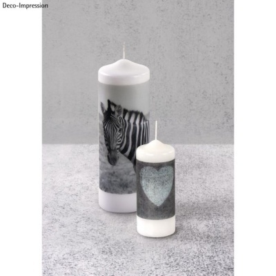 Duas velas brancas com imagens de zebra e coração sobre superfície cinzenta