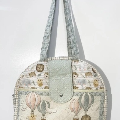 Mala de tecido com padrão de balões de ar quente e animais em tons pastel