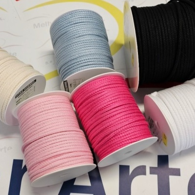 Rolos de cordões de algodão coloridos sobre superfície com texto