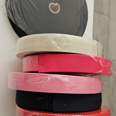 Rolos coloridos de fita têxtil empilhados com plástico