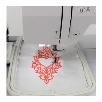 Máquina de costura bordando padrão em tecido branco