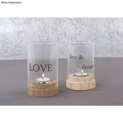 Dois castiçais de vidro com bases de madeira e velas acesas