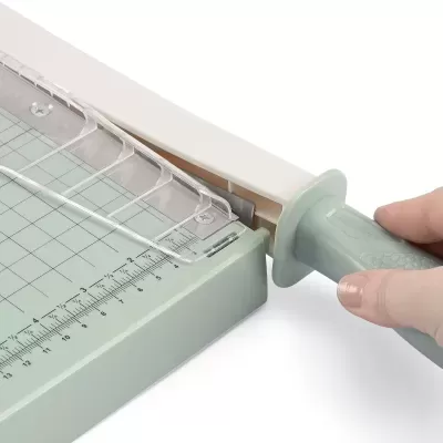 Guilhotina de papel cinza claro com marcações e cabo cinza
