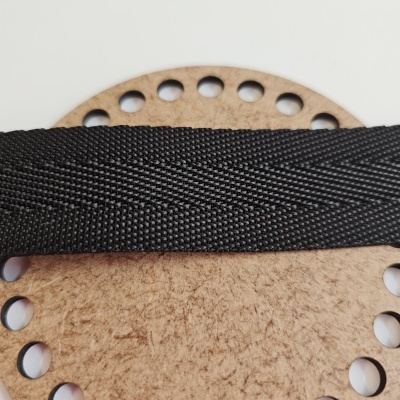 Tira preta de tecido sobre disco redondo de madeira com furos