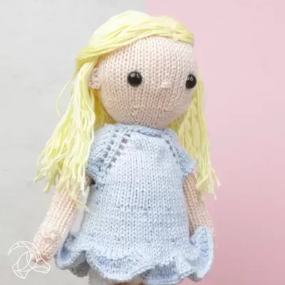 Boneca de tricot com vestido azul claro e cabelo amarelo
