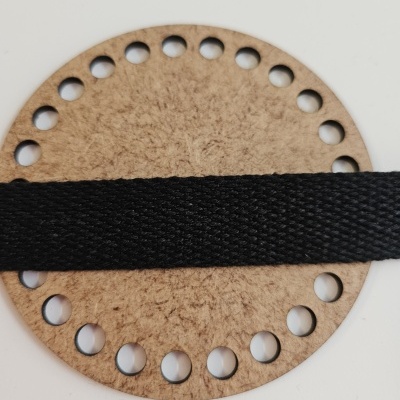 Anel redondo de cortiça com furos e fita preta entrelaçada no meio