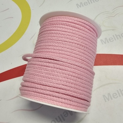 Carretel de cordão rosa sobre superfície decorada