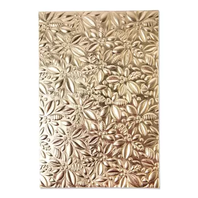 Caderno dourado com padrão floral em relevo.