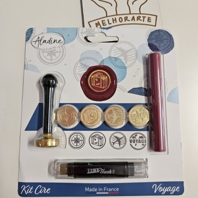 Kit de cera para selos com cabo preto e dourado, selos metálicos, vela vermelha e isqueiro preto em embalagem branca e azul com temática de viagem