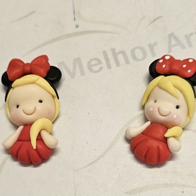Duas figuras decorativas de menina com vestido vermelho e acessórios Minnie Mouse