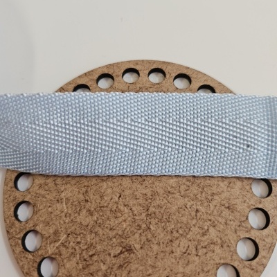 Tira de tecido cinzento claro sobre suporte redondo de madeira com orifícios