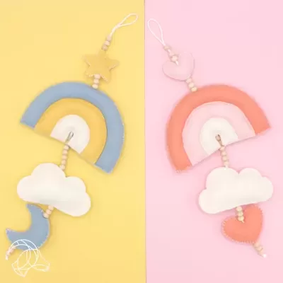 dois móbiles decorativos em tecido com arco-íris, nuvens e formas celestiais