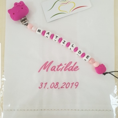 Tecido branco com nome e data bordados em rosa e porta-chupetas personalizado com contas rosa e brancas