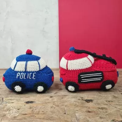 Brinquedos de carros de croché azul e vermelho sobre madeira
