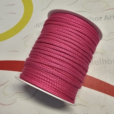 Carretel de cordão rosa grosso sobre suporte branco