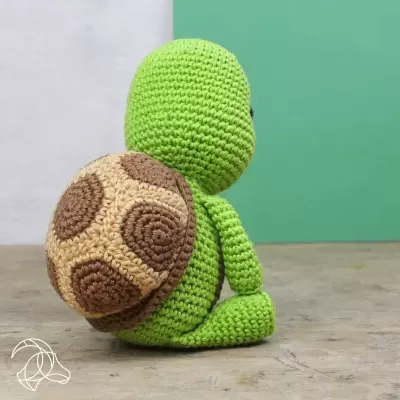 Boneco de tartaruga de croché verde com casco castanho