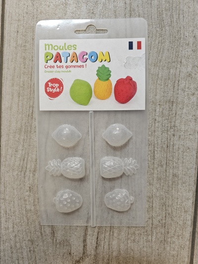 Moldes transparentes para fazer borrachas com formas de frutas numa embalagem com texto em francês.