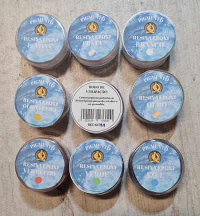 Conjunto de potes de resina epóxi Pigmento com diferentes cores em tampas azuis, sobre uma superfície clara