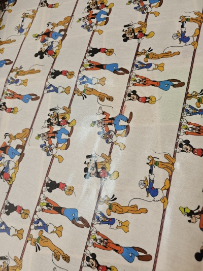 tecido estampado com personagens Disney em padrão repetido