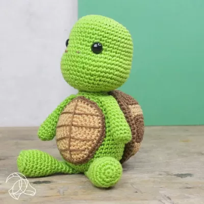 Boneco de tartaruga de crochet verde com barriga bege e carapaça castanha