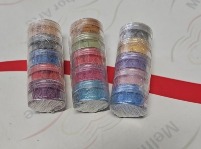 Três pilhas de pequenos recipientes circulares coloridos embalados em plástico transparente