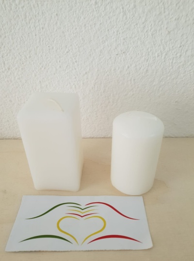 Duas velas brancas e cartão decorado com desenho colorido em forma de coração