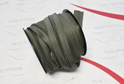 Rolo de fecho éclair verde-oliva sobre suporte preto