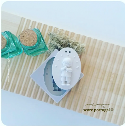 Molde de silicone, duas pequenas garrafas de vidro verde com rolhas e musgo decorativo sobre superfície de madeira clara