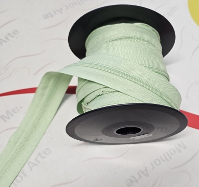 Rolo de fecho éclair verde claro em carretel preto