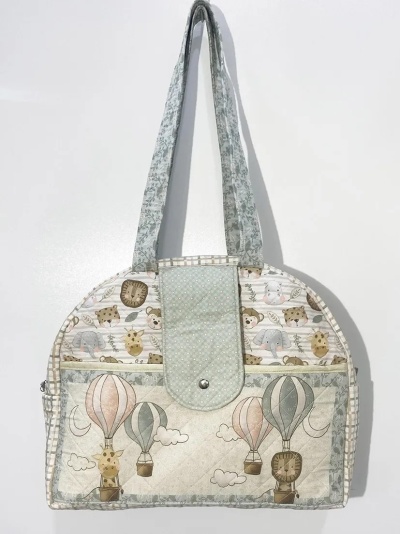 Mala de tecido com padrão de balões de ar quente e animais em tons pastel