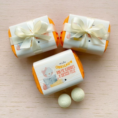 Sabonetes embrulhados com ilustração de coelho e laço de cetim sobre madeira clara