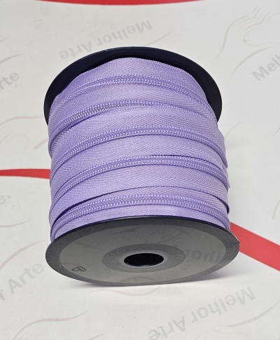 Rolo de fita lilás num carretel preto sobre superfície branca com texto