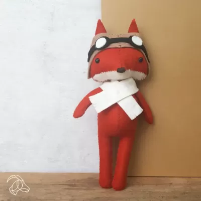 Boneco de raposa em tecido vermelho com cachecol branco e óculos preto