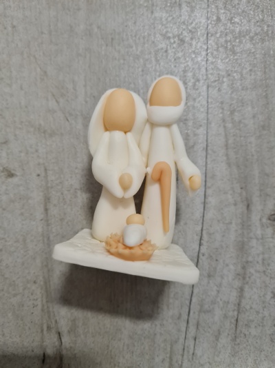 Presépio branco e bege minimalista com figuras sem rosto em celeiro branco