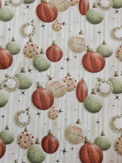 Tecido com padrão de bolas de Natal vermelhas e verdes, coroas e estrelas pretas em fundo branco listrado.