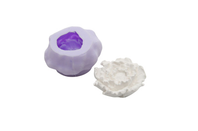 Molde de silicone lilás com peça branca em forma de flor.