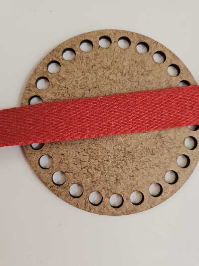 Base circular de cortiça com furos e fita vermelha