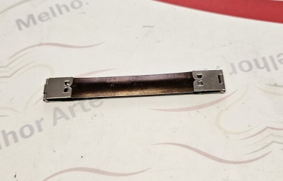 Barra metálica estreita com parafusos sobre superfície branca com texto parcial