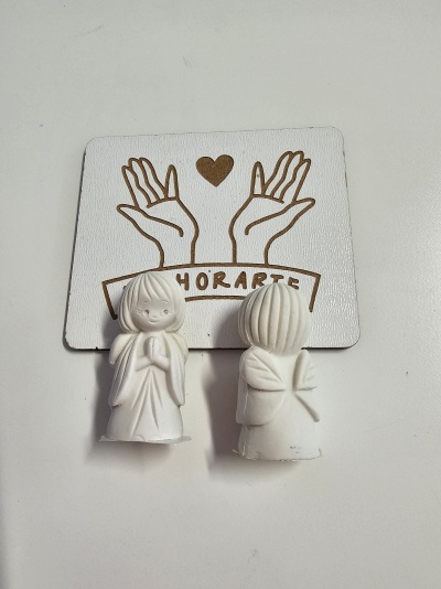 Duas figuras brancas de anjo em cerâmica ou gesso com mãos em oração