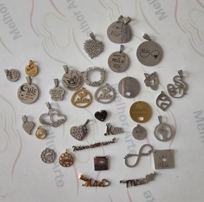 Medalhas e pendentes metálicos com textos sobre a mãe em fundo branco