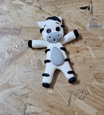 Figura de vaca branca e preta em superfície de madeira clara