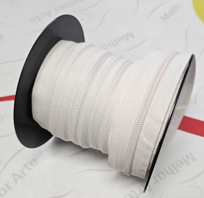 Rolo de zíper branco num carretel preto