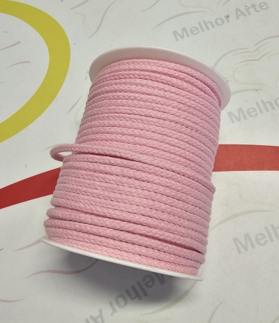 Carretel de cordão rosa sobre superfície decorada