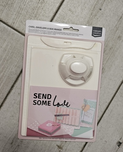 Kit para fazer cartões, envelopes e caixas com ferramenta e carimbo, embalagem com texto e imagens ilustrativas.