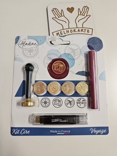 Kit de cera para selos com cabo preto e dourado, selos metálicos, vela vermelha e isqueiro preto em embalagem branca e azul com temática de viagem