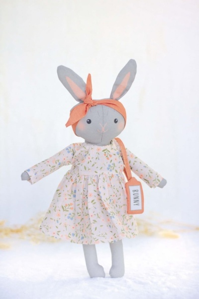 Boneca de peluche coelho vestido floral com lenço laranja e etiqueta 'BUNNY'