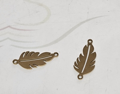 Dois pendentes castanhos em forma de pena sobre superfície clara